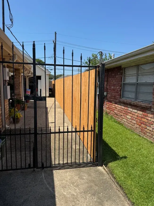 Wrought iron gate with wood fence