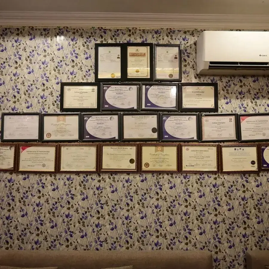 Wall of dental certifications and conference participation certificates